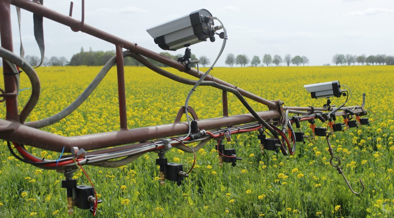 WeSee-Kameras und Einzeldüsenventile, nachgerüstet an einem vorhandenen Spritzgestänge im Feld.