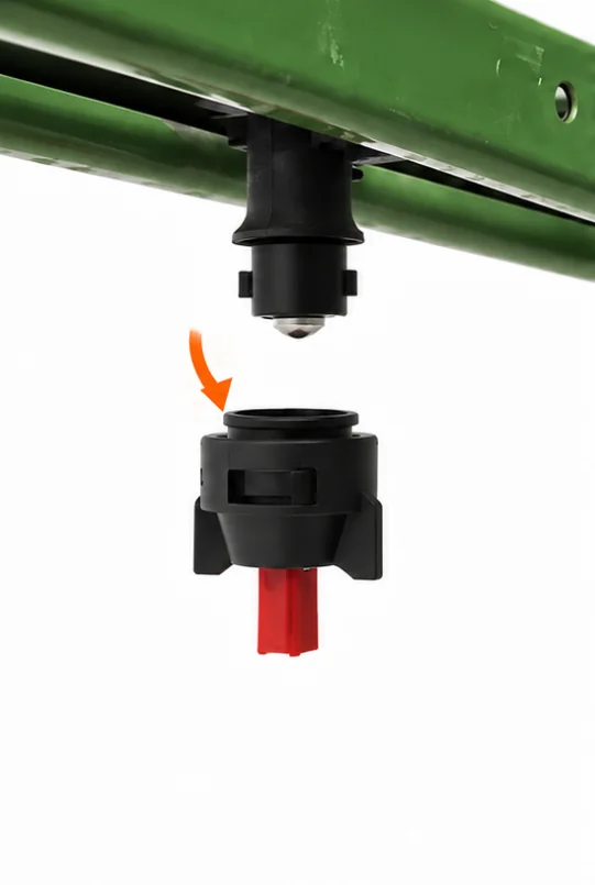 Die originale Düsenkappe wird vom Düsenkörper unter einem grünen Spritzgestänge abgenommen.