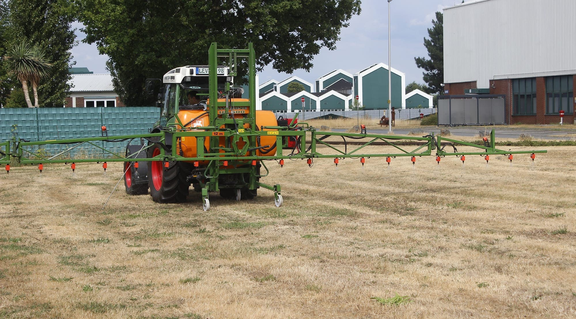 Eine am Traktor angebaute Spritze mit voll ausgeklapptem Gestänge, nachgerüstet mit einzelnen WeSee-Düsenventilen.