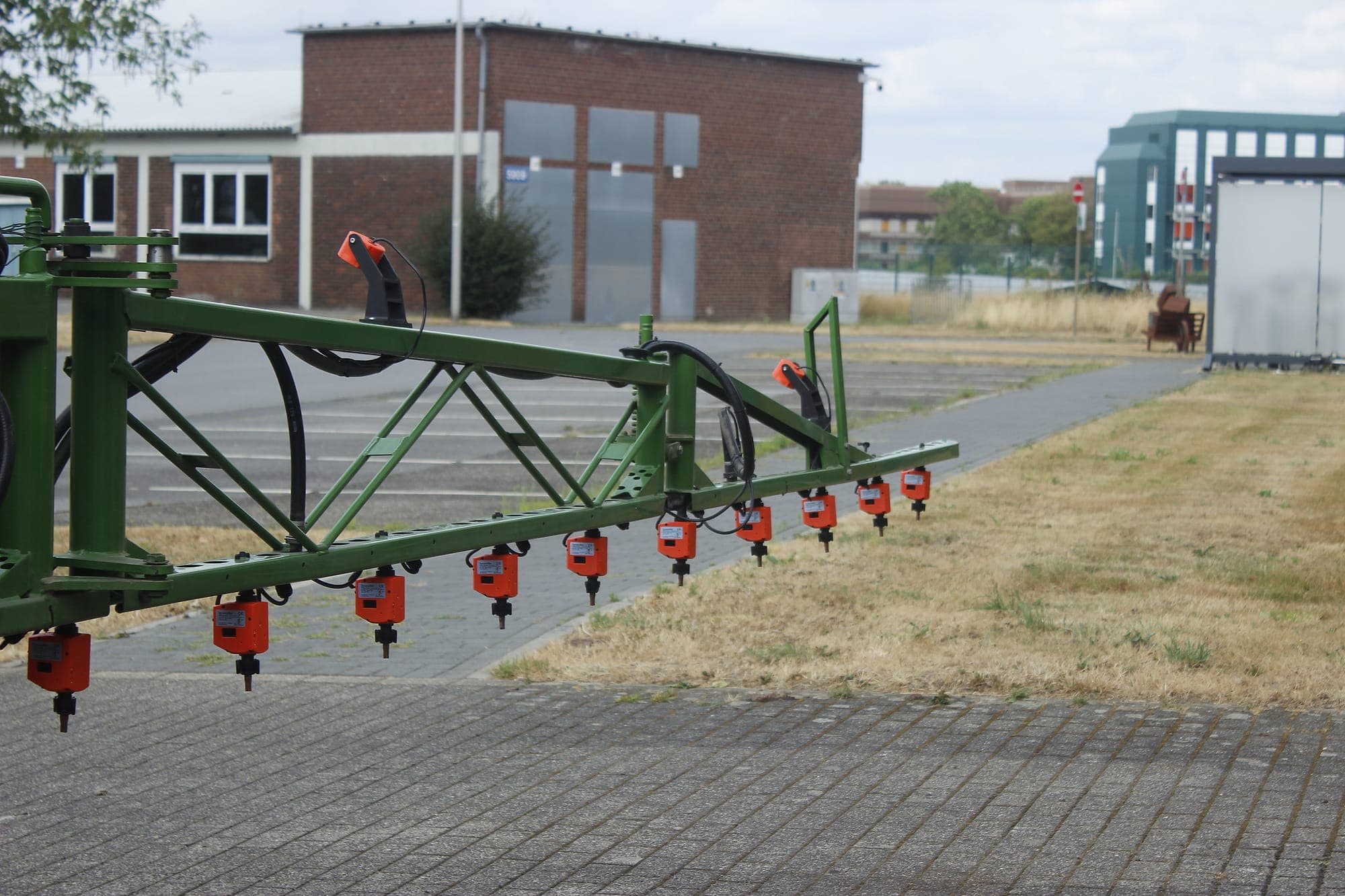 Einzelne WeSee-Düsenventile, nachgerüstet entlang eines vorhandenen Spritzgestänges.