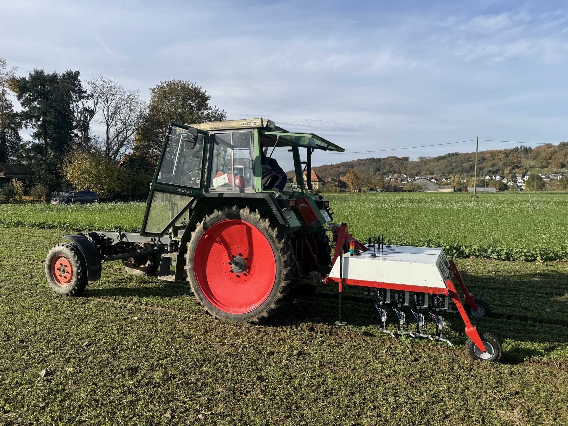 El apero WeWeed montado en un tractor, listo para una demostración en el campo.