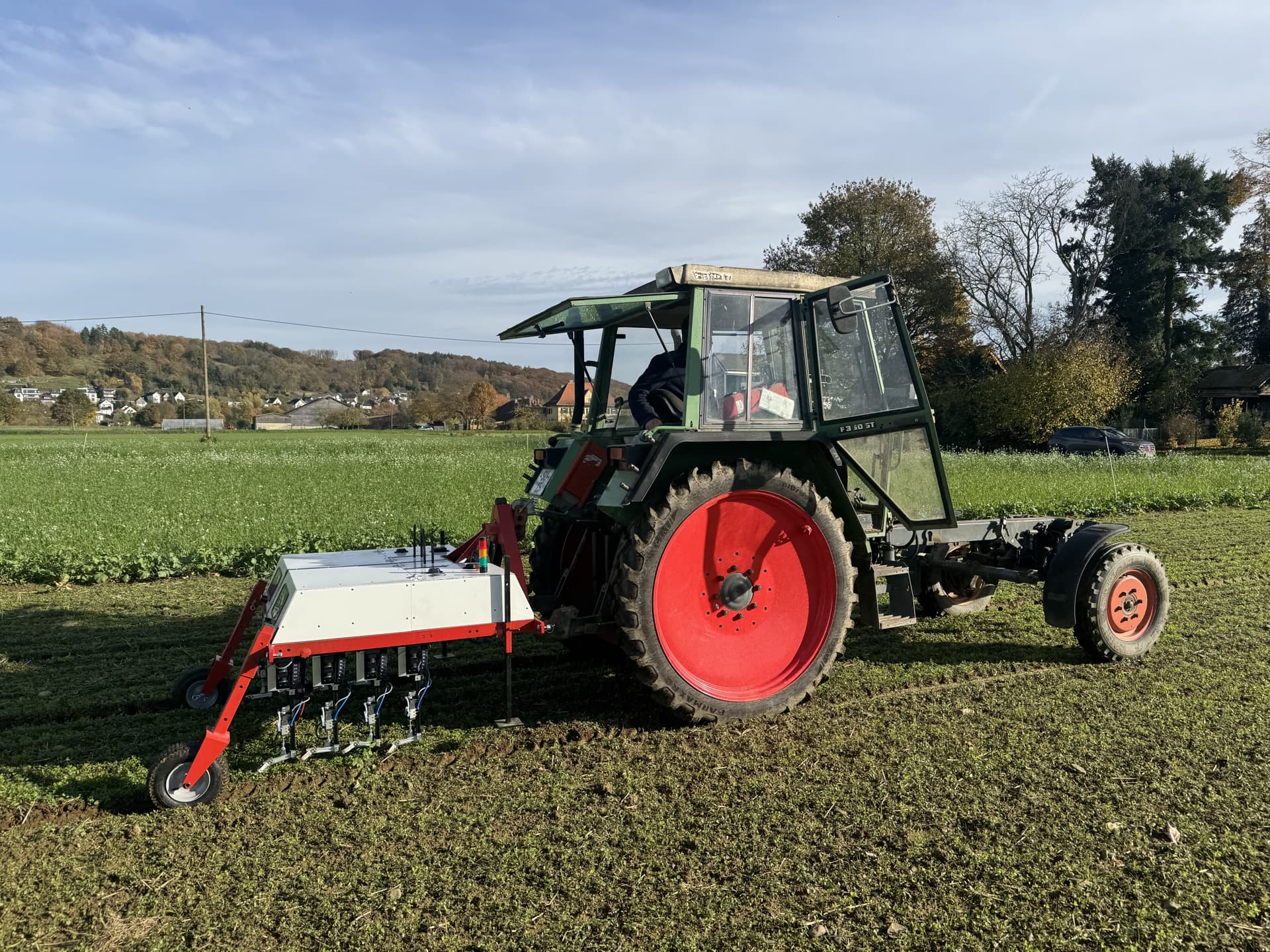 Das WeWeed-Anbaugerät an einem Traktor, bereit für eine Felddemo.