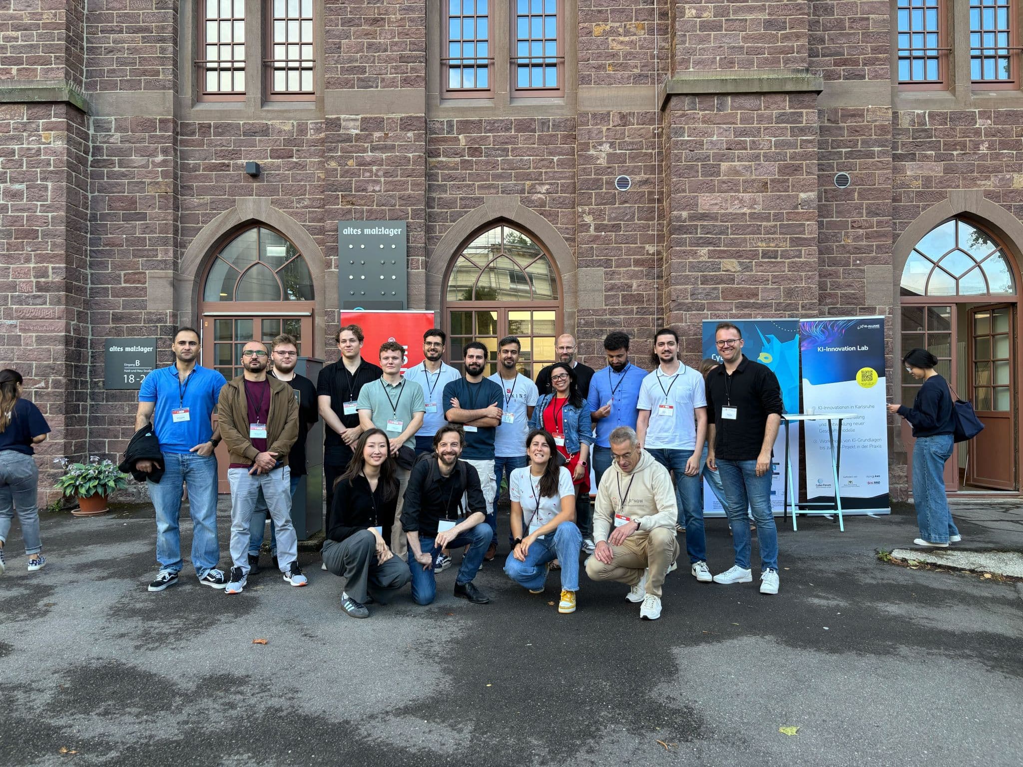 Gruppenfoto von rund fünfzehn DynamoBot-Teammitgliedern vor einem roten Backsteingebäude der Universität Bonn.